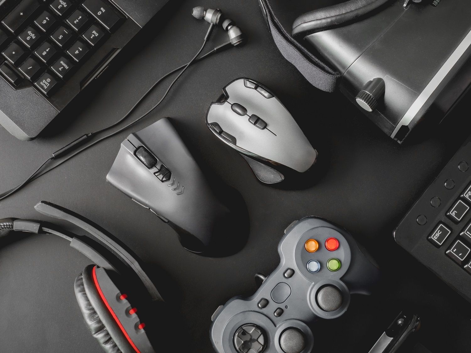 Les périphériques d’un PC gamer : une souris, un clavier, un casque gaming, une manette et un casque de VR