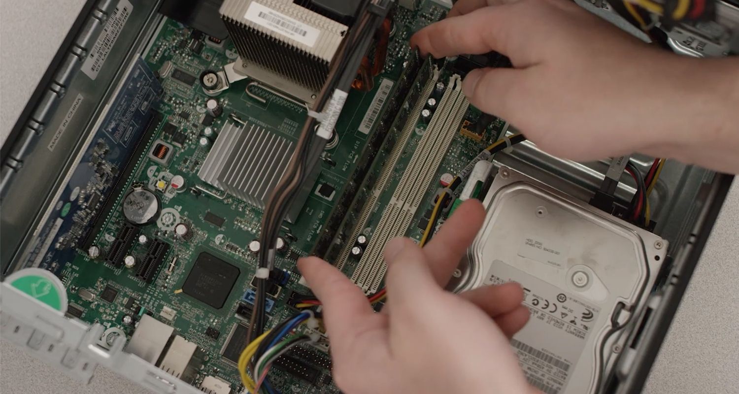 Une personne retirant un module de RAM d’un ordinateur de bureau