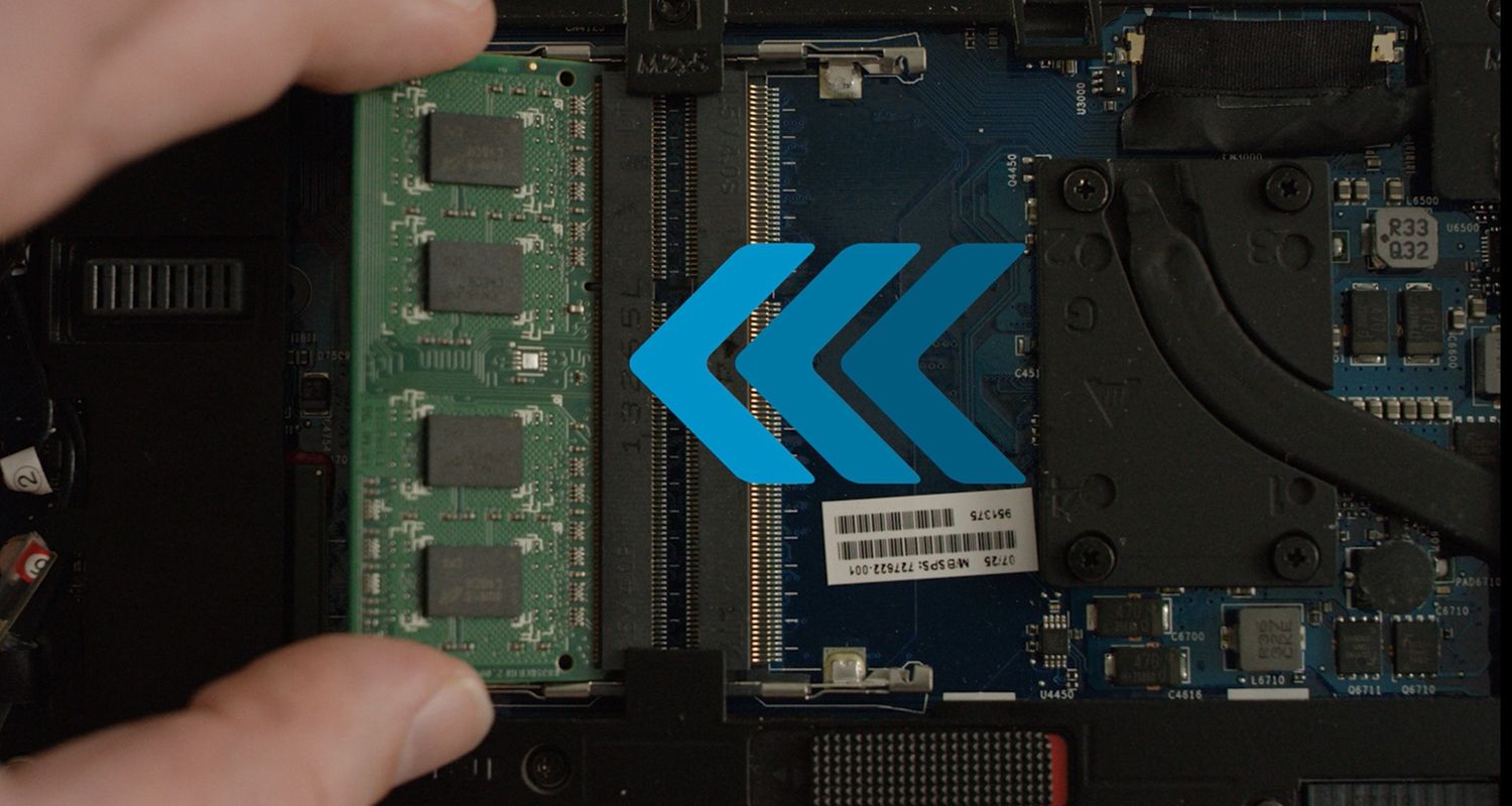 Une personne installant un module de RAM Crucial dans un ordinateur portable